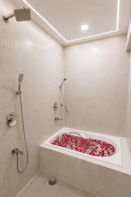 a bathroom with a bath tub filled with red hearts at Lake Bloom Residency in Mumbai