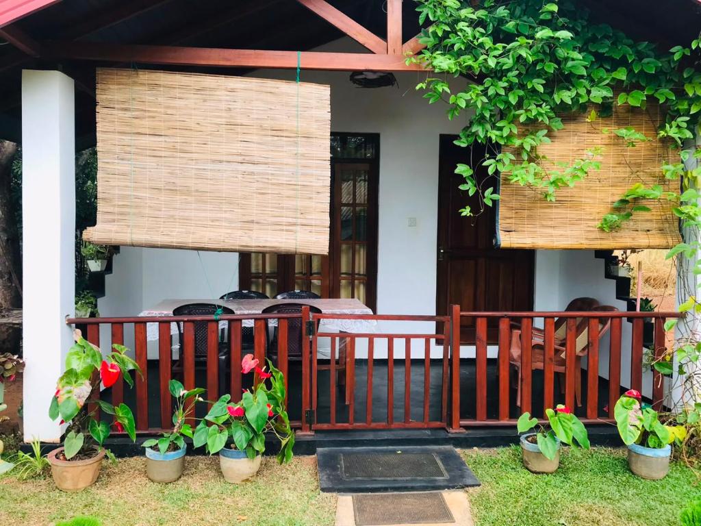 a porch of a house with potted plants on it at Sigiri White Queen's Lodge in Sigiriya