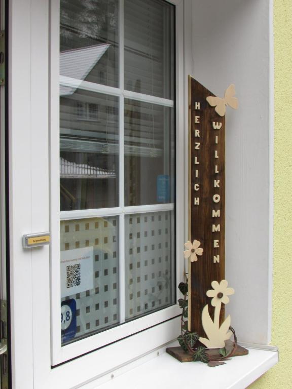 a window with flowers and a butterfly on it at FeWo Harz Haennig 2 in Walkenried