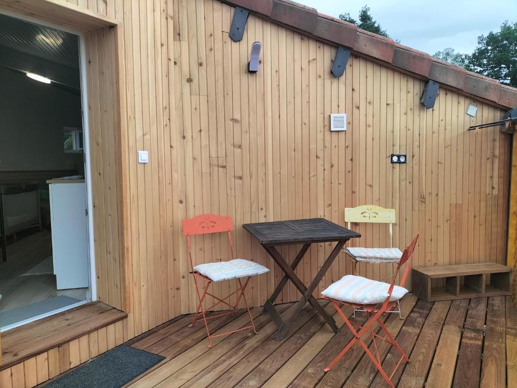 two chairs and a table on a wooden deck at Chemin de Bizous in Montoussé