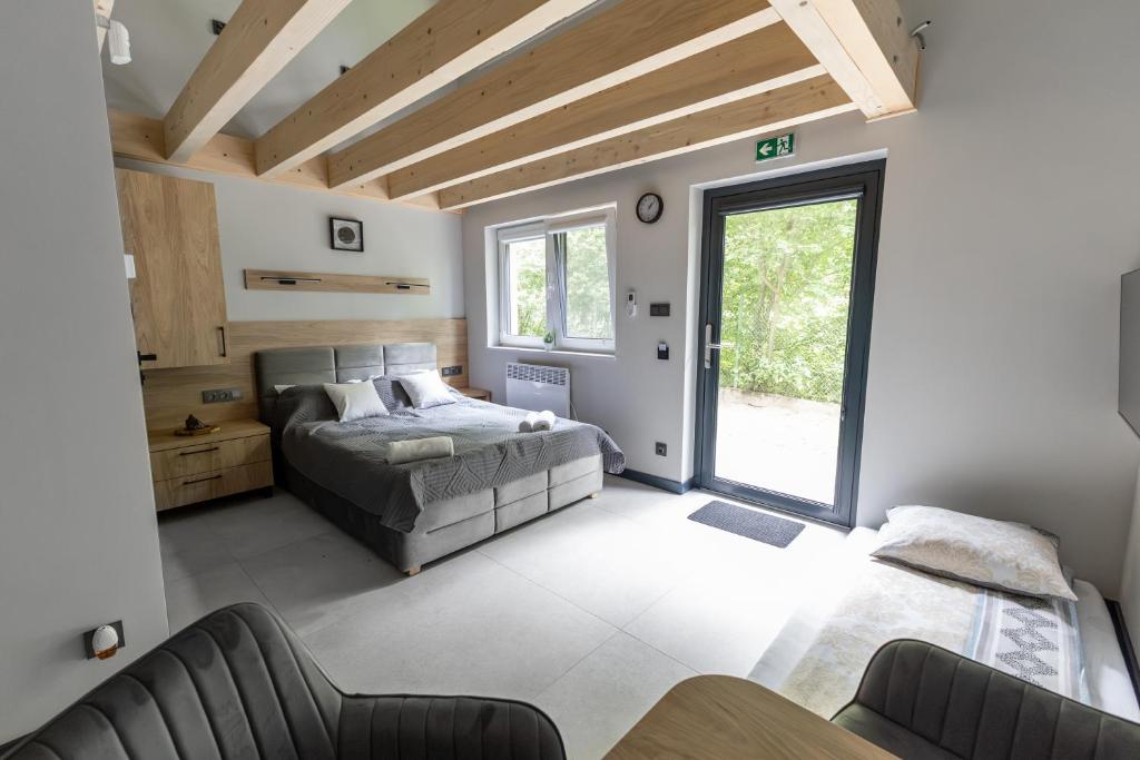 a bedroom with a bed and a large window at Serce Lasu - Hotel z Duszą i Energią Kamieni in Czarna