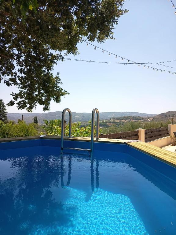 a large blue swimming pool with a view at Anesis House in Stroumbi