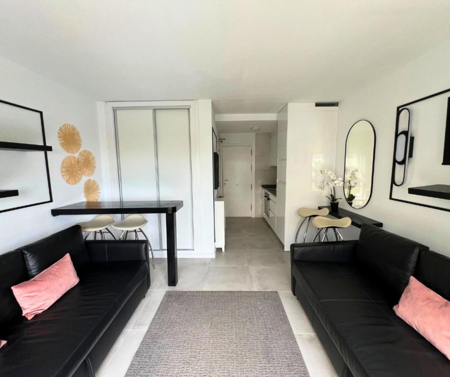 a living room with a black couch and a table at Apartamentos Benal Beach Group in Benalmádena