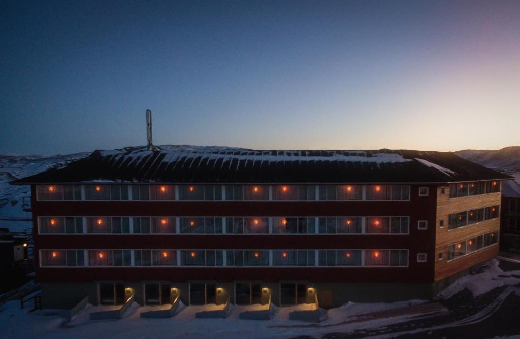 a building in the snow with lights on it at Hotel Arctic in Ilulissat