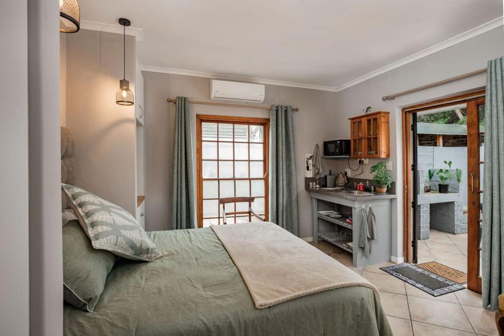 a bedroom with a bed and a table and a window at Santa Stay in Stellenbosch