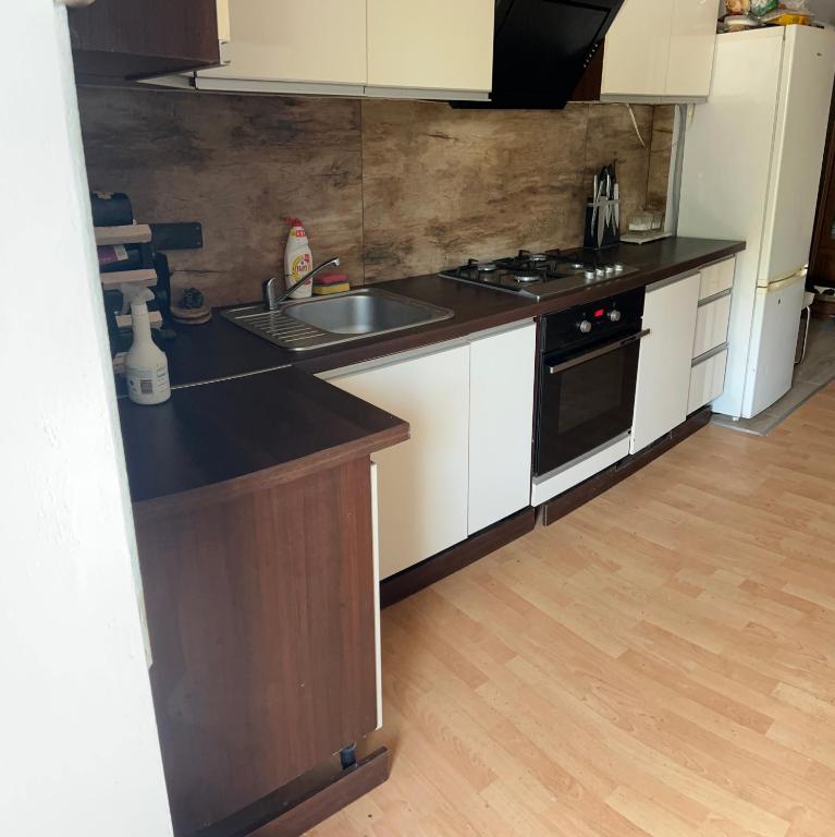a kitchen with white cabinets and a black counter top at Dolna 64 in Strzegom
