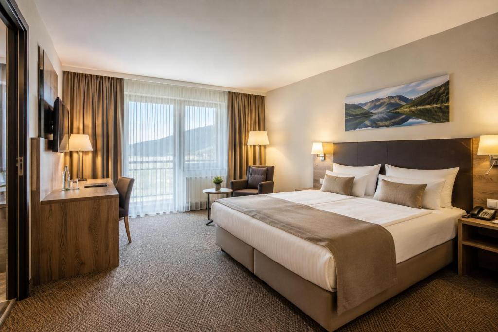 a hotel room with a large bed and a large window at Hotel M K in Nuremberg