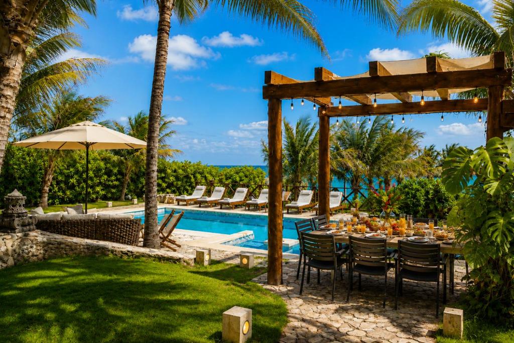 a table with food on it next to a pool at Casa Seven Ocean Front with Private C hef Included in Isla Mujeres