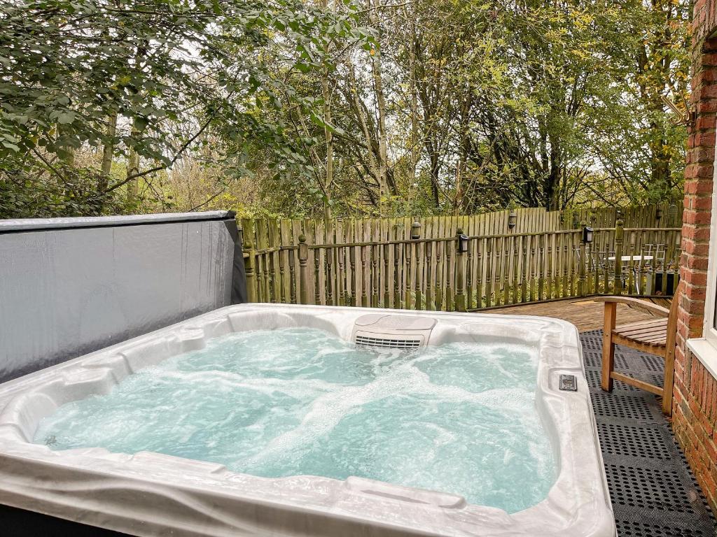 a hot tub in a backyard with a fence at Haven In The Burn in Newburn