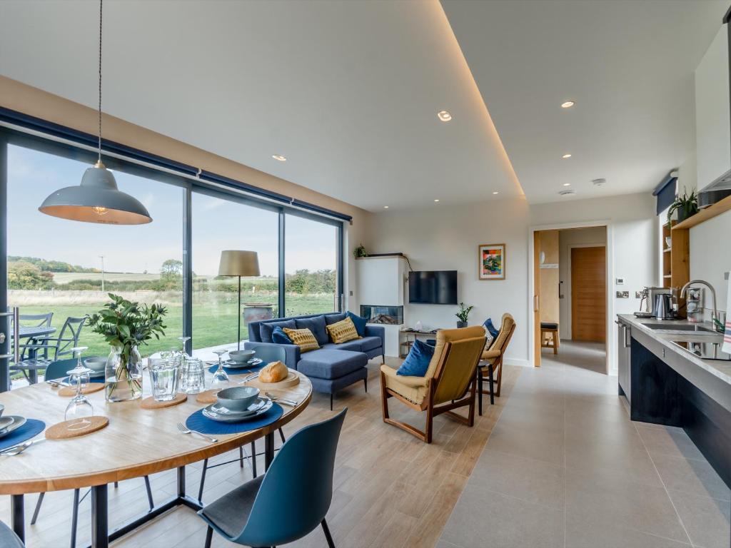 a kitchen and living room with a table and chairs at Buttercup Lodge - Uk36655 in Boothby Pagnell