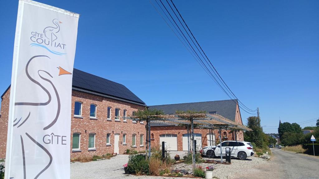 a sign in front of a brick building at Gîte du Coupiat in Walcourt