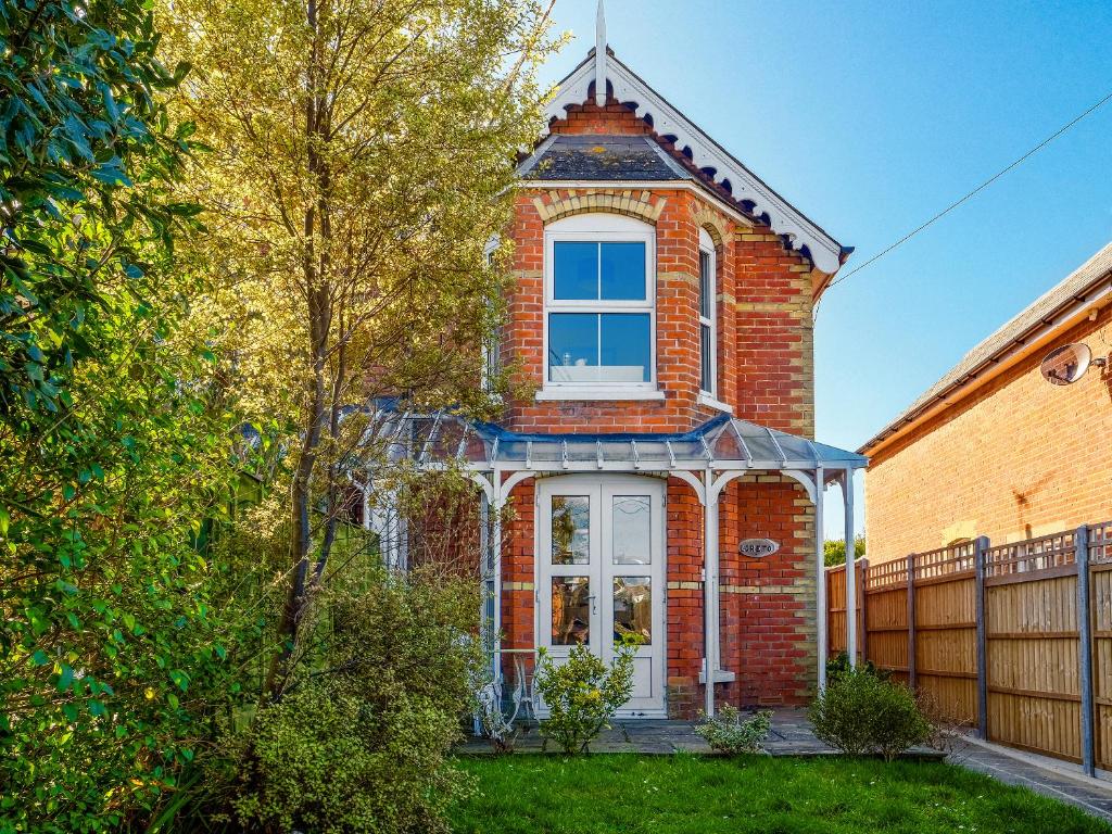 a brick house with a white door and a fence at Loreto in Freshwater