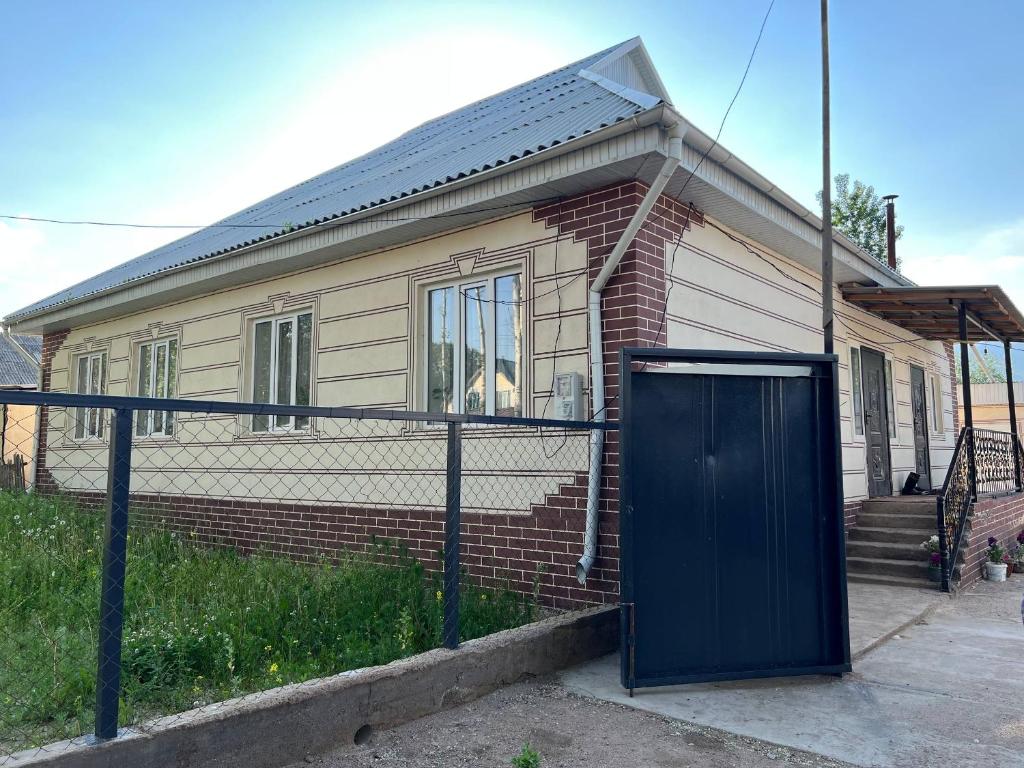 a house with a blue door in front of it at Keremeti guest house in Dzhangyaryk