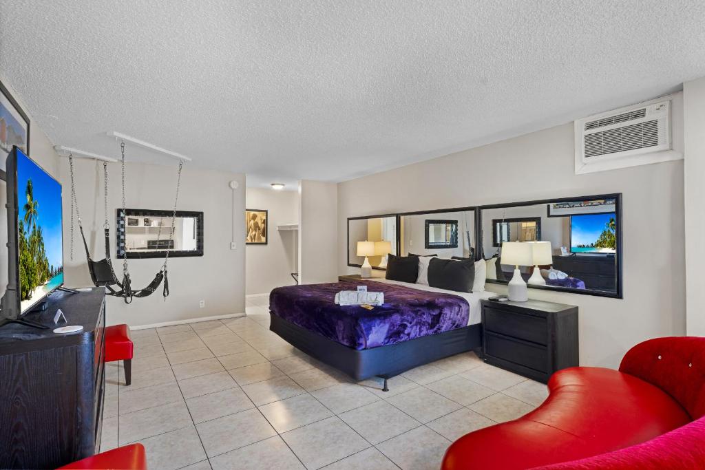 a bedroom with a bed and a tv and a couch at RoofTop Resort - Hollywood Beach, Florida in Hollywood