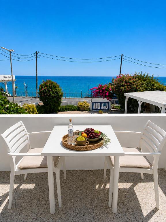 a white table and chairs with a bowl of fruit at Antonios Apartments Stegna in Archangelos