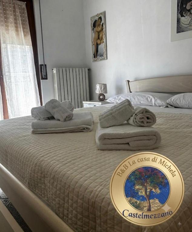 a bed with towels on it with a sign on it at B&b La Casa di Michela in Castelmezzano