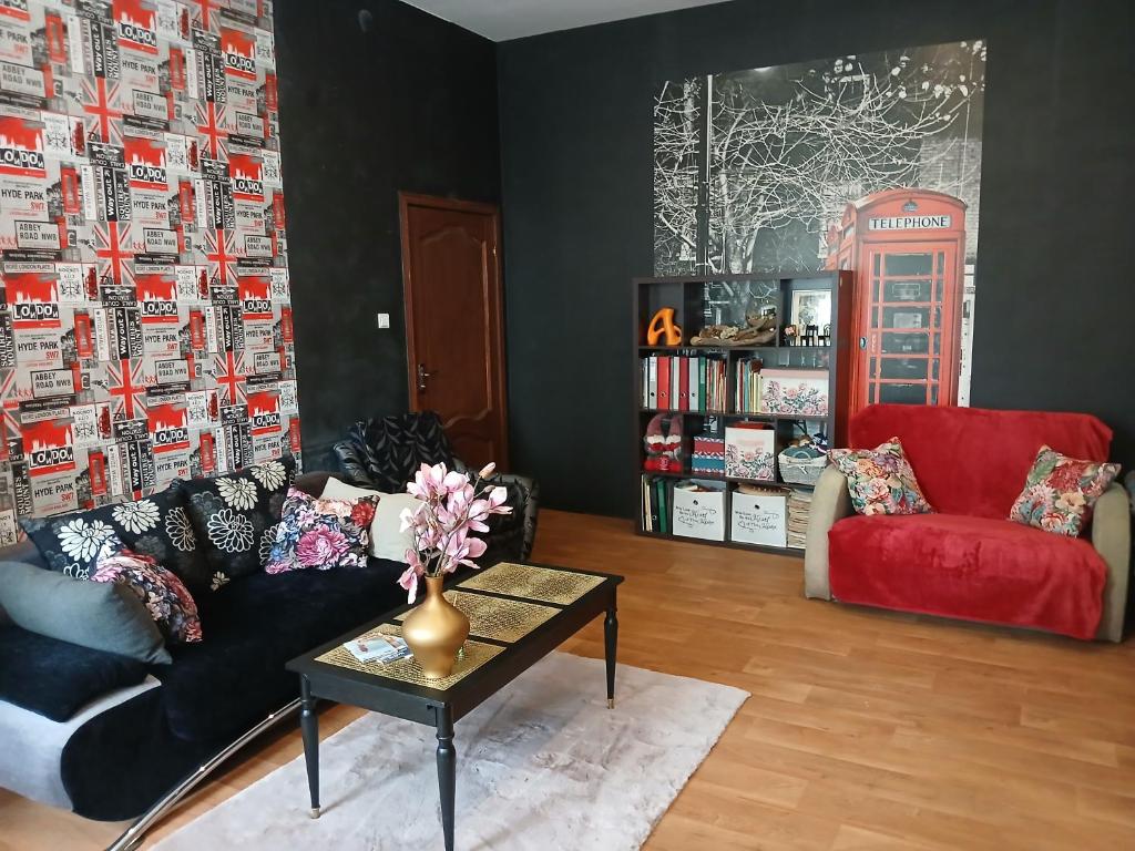 a living room with a couch and a red chair at Tosmare Apartament in Liepāja