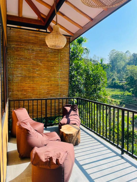 a balcony with two chairs and a table on a balcony at Treetops ella in Ella