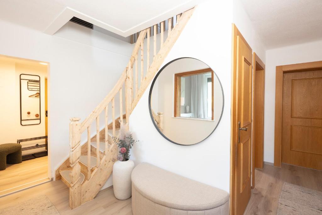 a hallway with a mirror and a stairway at Familienparadies - Chalet Hoamatl in Achenkirch