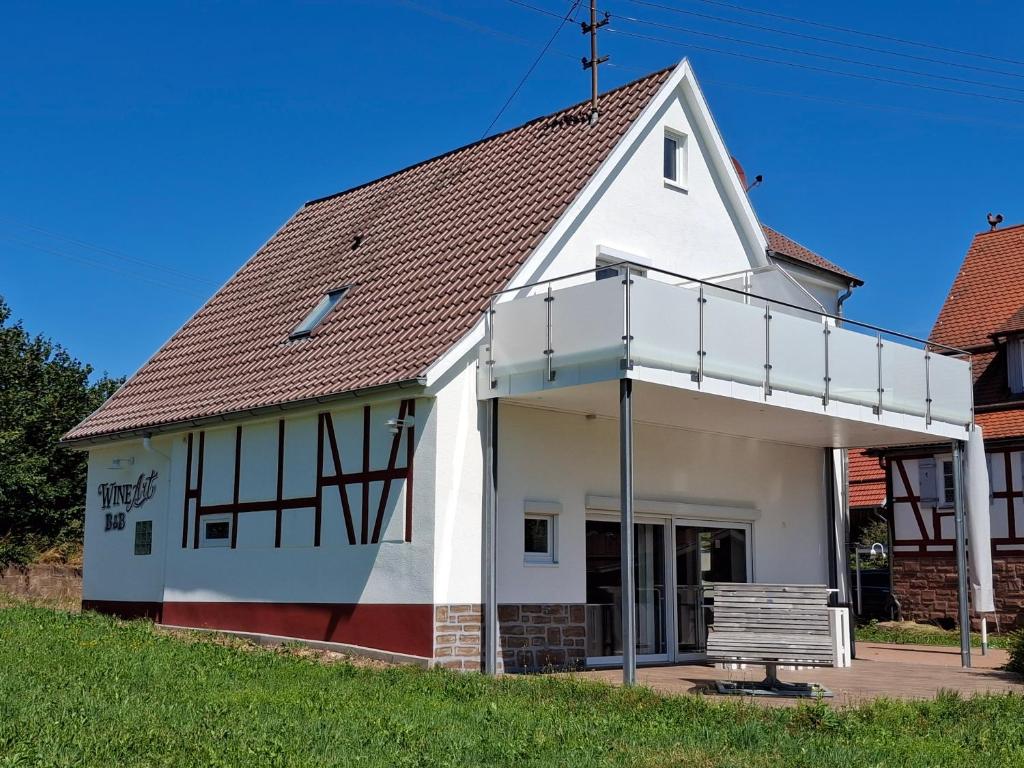 an old white church with a bench in front at WineArtB&B in Oberreichenbach