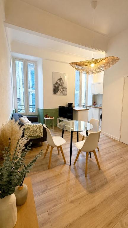 a living room with a table and chairs and a kitchen at Charmant appartement dans le centre ville in Bagnères-de-Bigorre
