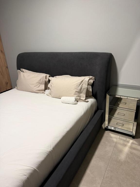 a bed with a black headboard and a glass table at Highveld Nook in Sasolburg