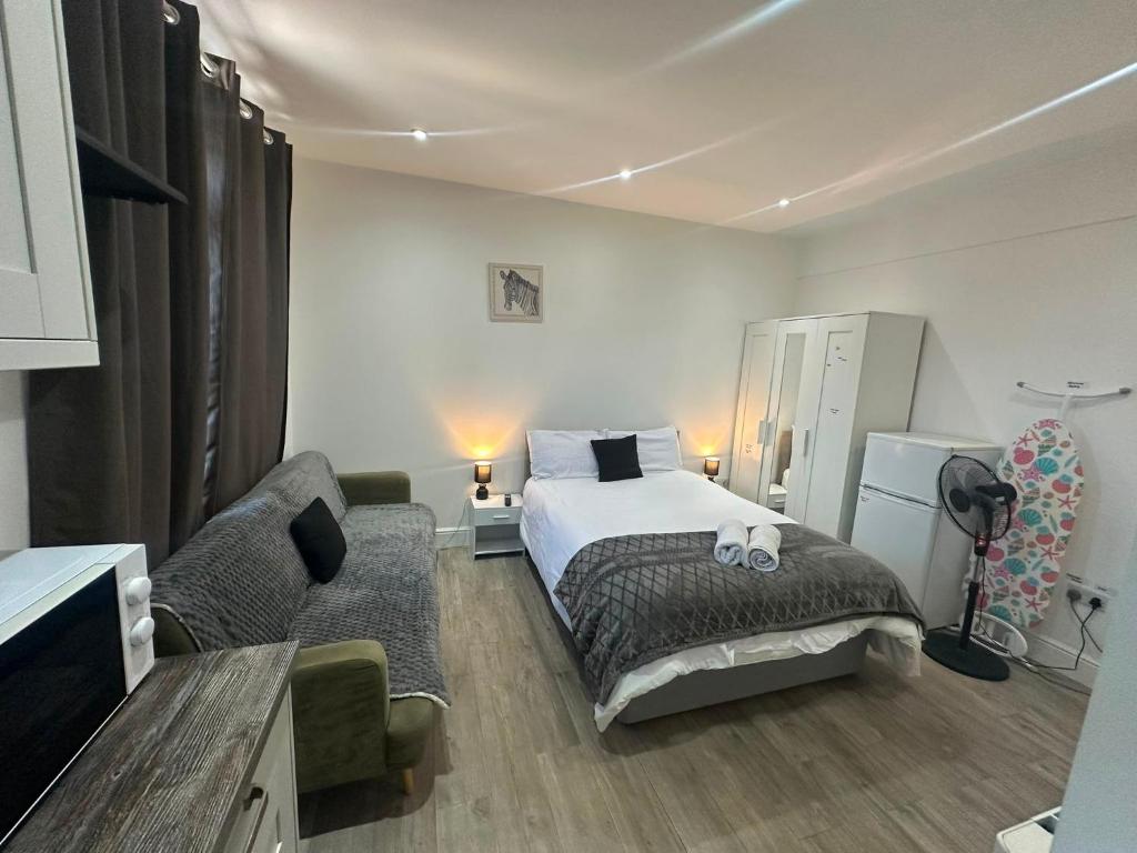 a bedroom with a bed and a couch at Wimbledon Family Studio Flat 1 in London