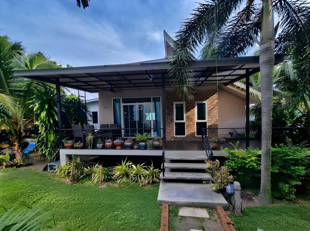 a house with a porch with palm trees at Zen Ocean Villa -Sri Thanu in Ko Phangan
