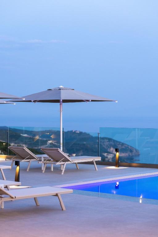 a pool with chairs and an umbrella on top of a building at Aurum Hotel in Palasë