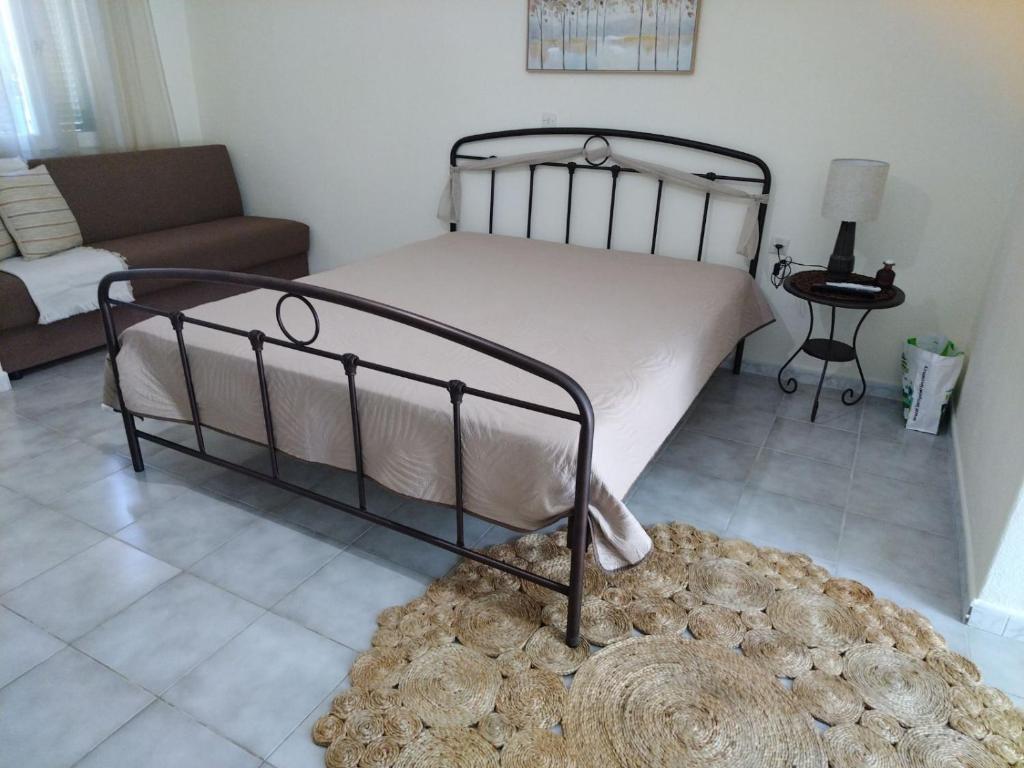 a bedroom with a bed and a couch and a rug at PanTheo Studio's in Tyros