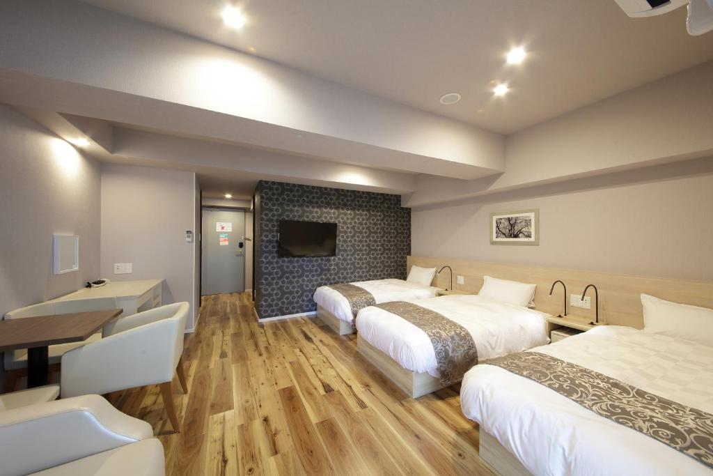 大阪市にあるSARASA HOTEL心斎橋のベッド2台、薄型テレビが備わるホテルルームです。