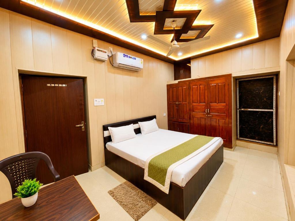 a bedroom with a bed and a table and a bed sidx sidx sidx at HOTEL VARANASI DV - Near Shree Kashi Vishwanath Temple in Varanasi