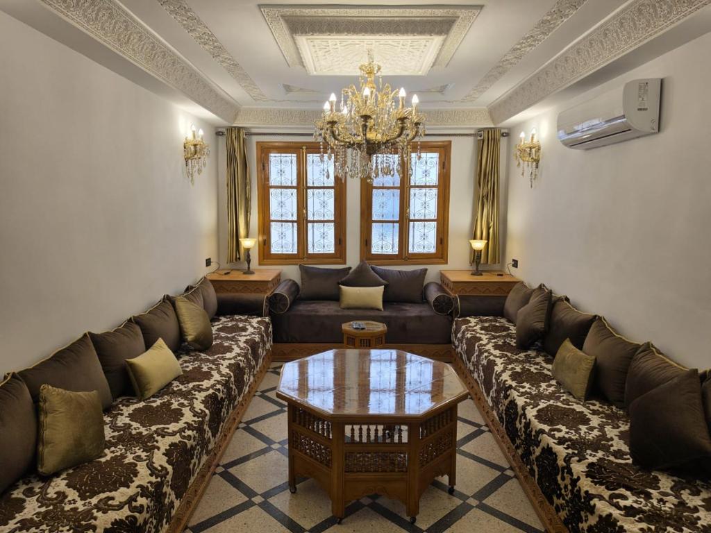 a living room with a couch and a table at Dar AWRABIA in Fez