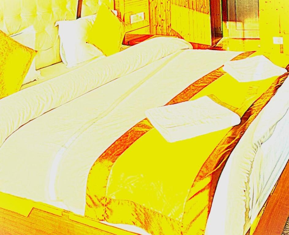 a yellow and white bed with a piece of paper on it at The Trisha Hotel in kolkata