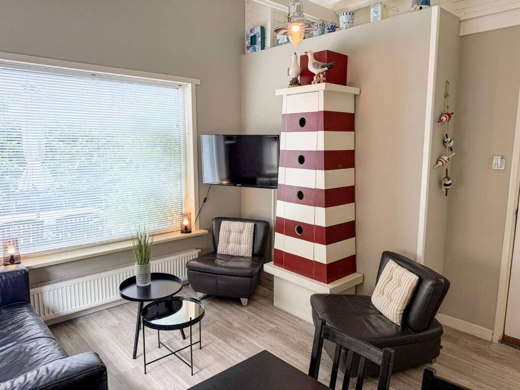 a living room with a couch and chairs and a table at Texelheerlijk 1 in De Koog