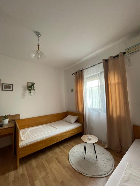 a bedroom with a bed and a table in it at Vinarija Andjusic in Dračevo