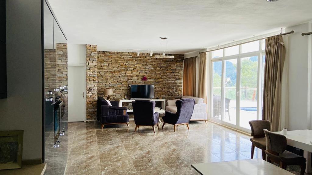 a living room with a table and chairs at Iztuzu Sunset Villa in Gökbel