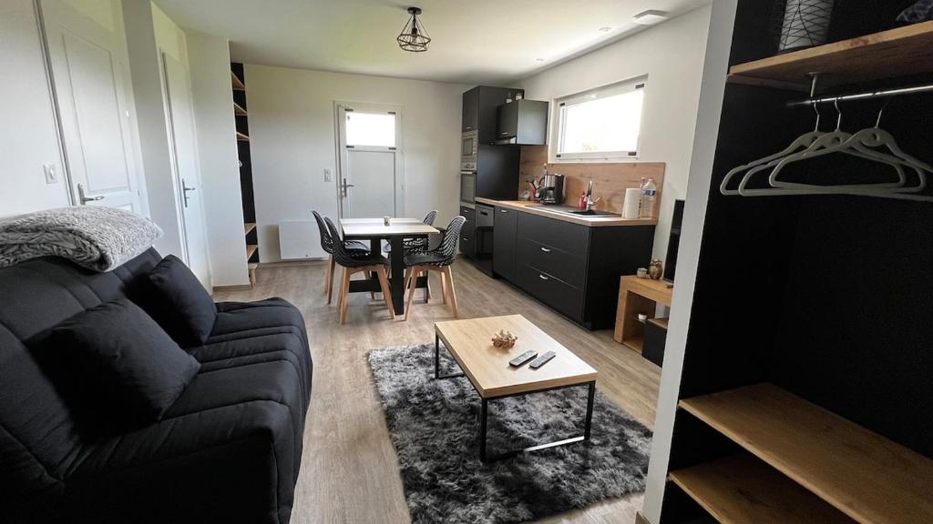 a living room with a couch and a table at Studio paisible, 30m2 in La Souterraine