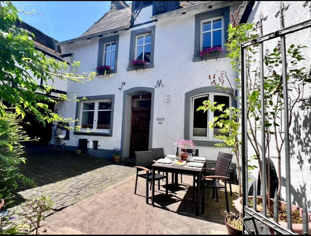 a table and chairs in front of a house at Ferienwohnung Haus Kreutz in Bruttig-Fankel
