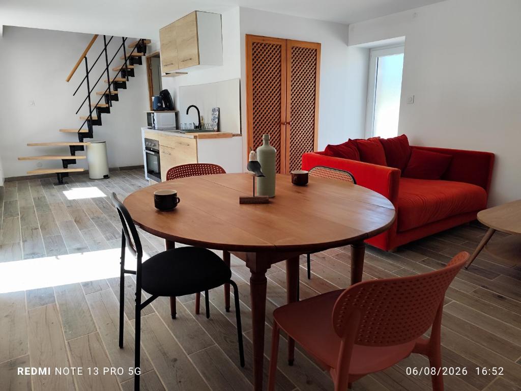 a living room with a table and a red couch at Ty eno in Plourin