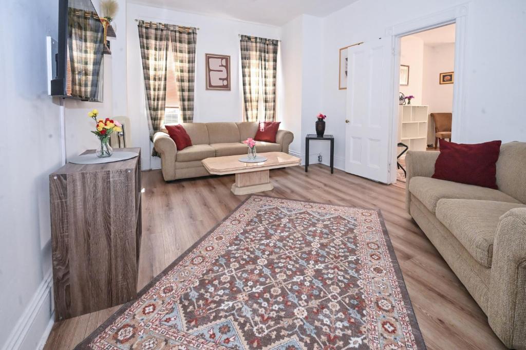 a living room with a couch and a rug at Sunny Haven House in Jersey City