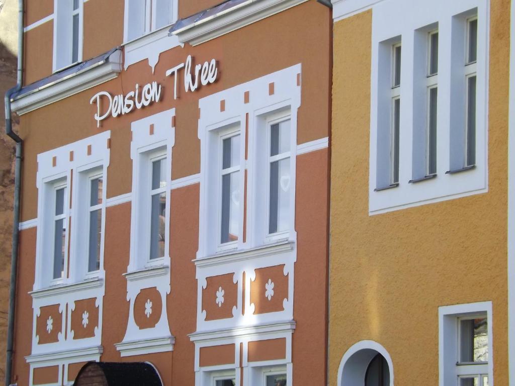 a building with a sign on the side of it at Pension Three in Františkovy Lázně