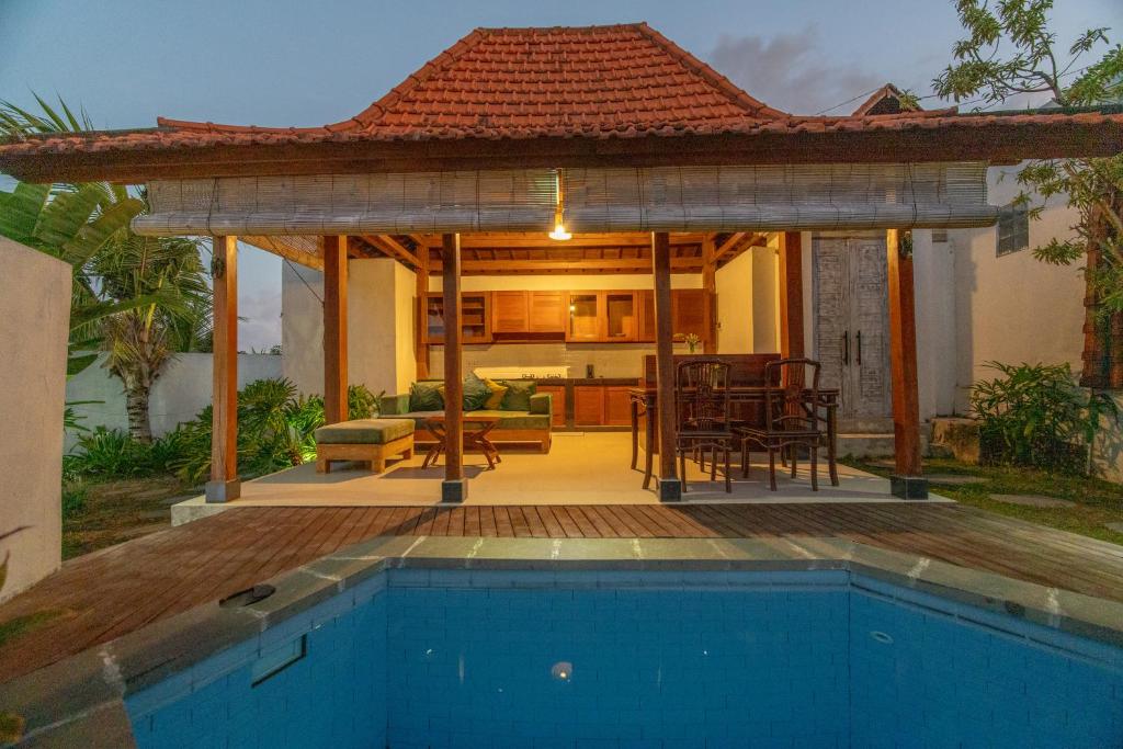 a gazebo with a pool in front of a house at Uma Jineng Villa in Munggu