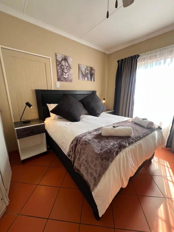 a bedroom with a large bed and a window at Kingfisher Hideaway in Nelspruit