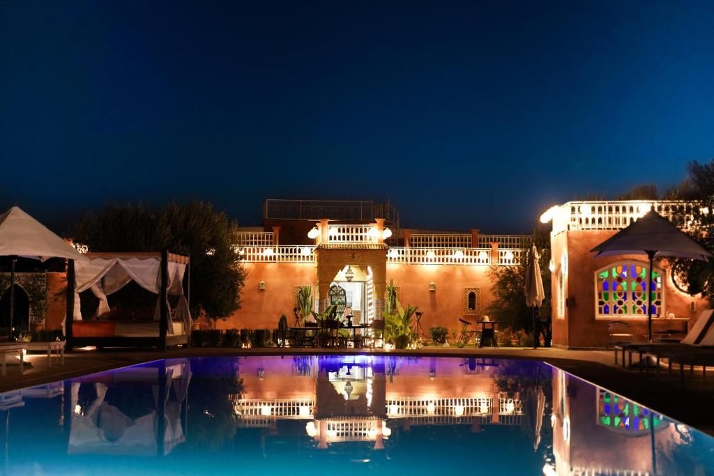 a building with a swimming pool at night at Palais Zoya in Marrakesh