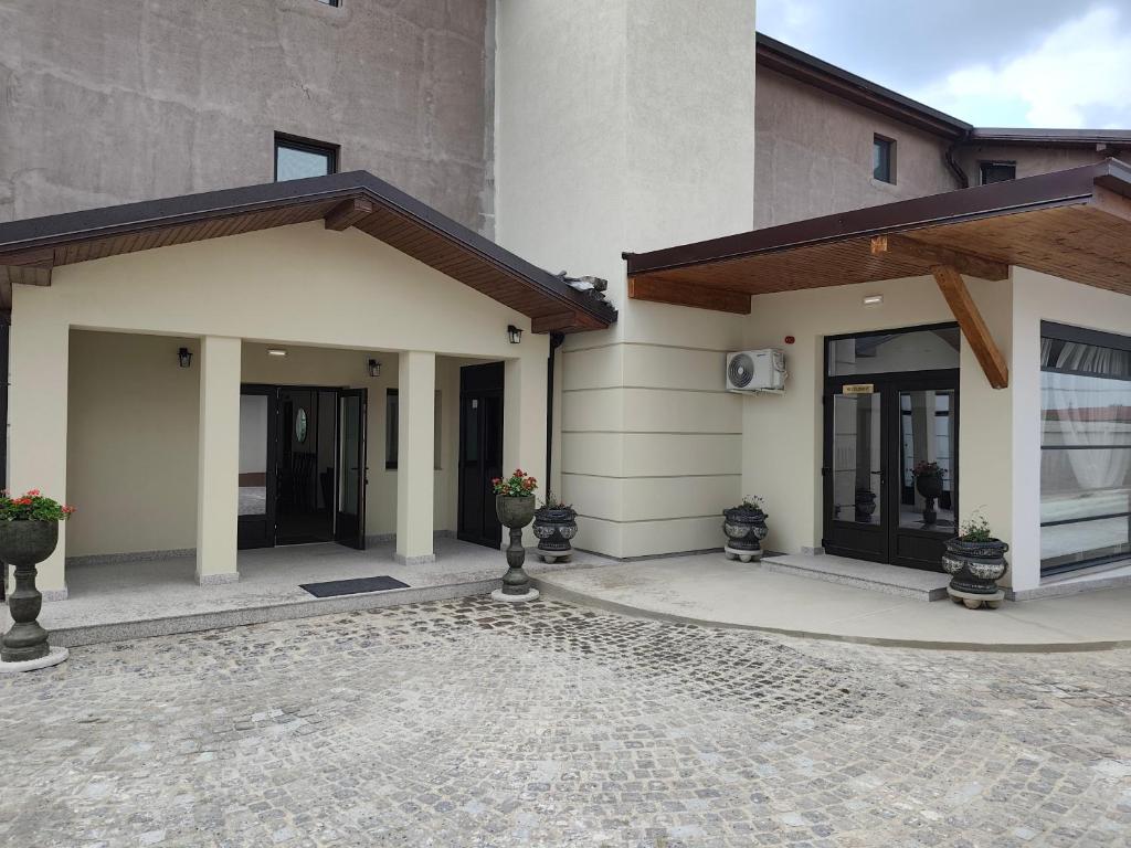 a house with a stone driveway in front of it at Hotel Amstar Simeria in Simeria