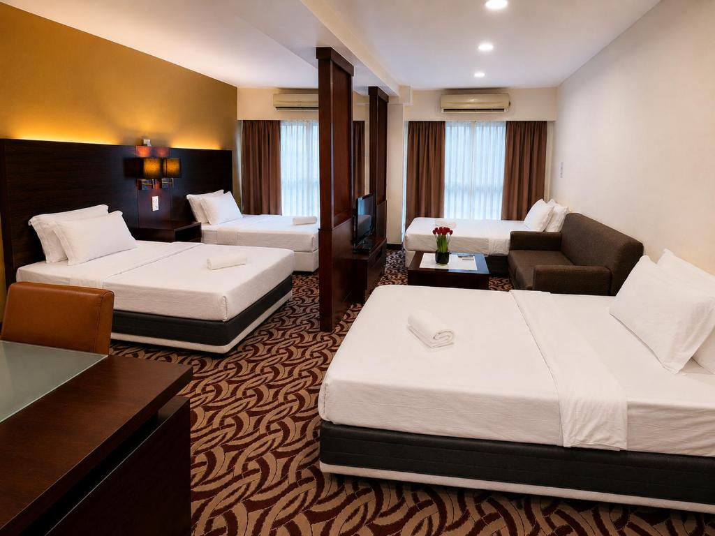 a hotel room with two beds and a couch at Cozy Studio at SCSP Suites in Kota Kinabalu