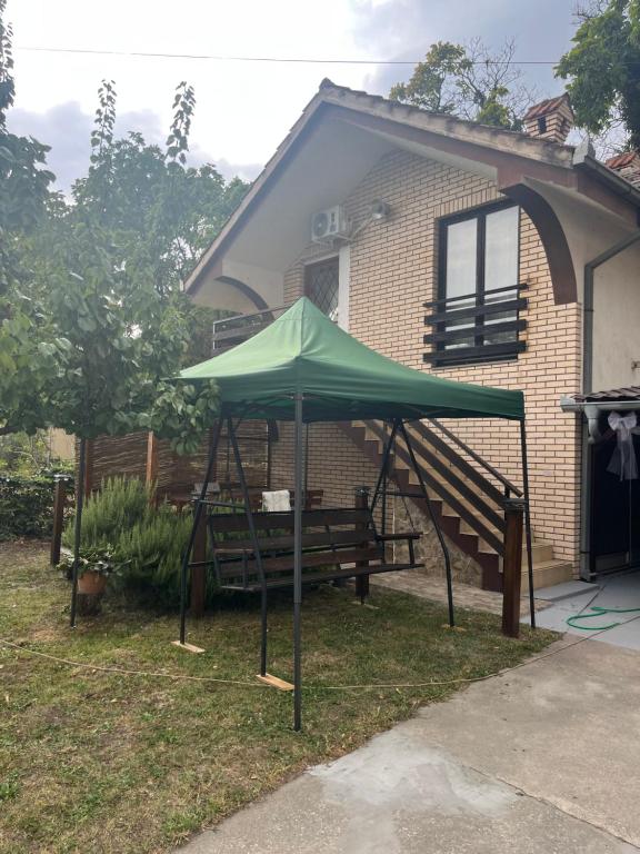 a green umbrella in front of a house at Apartman Jovana in Bečej