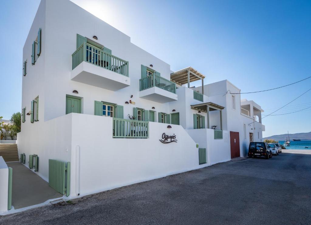 a white building with green doors and balconies at Almyris in Adamantas