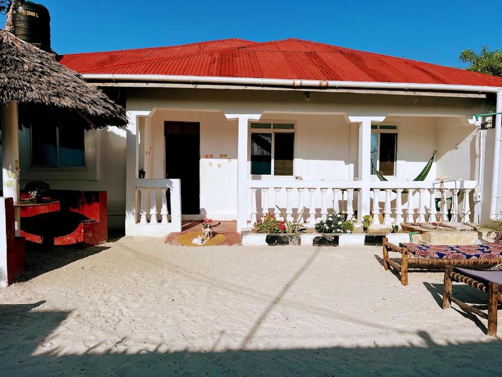 a small white house with a red roof at Meama Paje Guesthouse in Paje